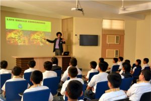 Teacher using computer and projector to teach students in class